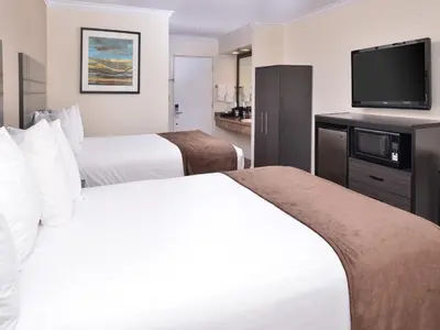 a hotel room with two beds and a flat screen tv at Best Western Capistrano Inn in San Juan Capistrano