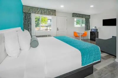 a bedroom with a large white bed and a table at Howard Johnson Suites by Wyndham San Diego Chula Vista BayFront in Chula Vista