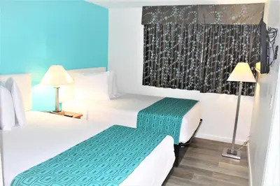 a hotel room with two beds and two lamps at Howard Johnson Suites by Wyndham San Diego Chula Vista BayFront in Chula Vista