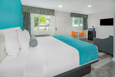 a bedroom with a large white bed and a table at Howard Johnson Suites by Wyndham San Diego Chula Vista BayFront in Chula Vista