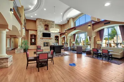 a large room with a lobby with chairs and a fireplace at Hampton Inn & Suites by Hilton Hemet Menifee Murrieta in Hemet
