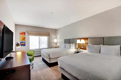 a hotel room with two beds and a desk at Hampton Inn & Suites by Hilton Hemet Menifee Murrieta in Hemet
