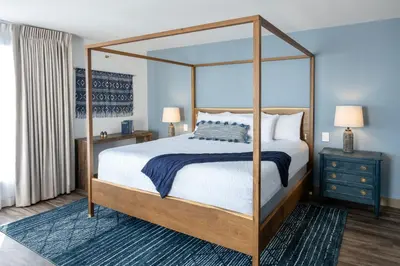 a bedroom with a canopy bed and a blue rug at Cardiff By The Sea Lodge in Encinitas