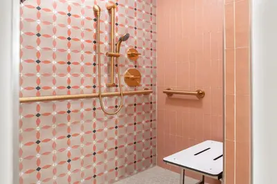 a bathroom with a shower with pink tiles at Cardiff By The Sea Lodge in Encinitas