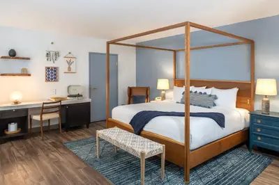 a bedroom with a canopy bed and a desk at Cardiff By The Sea Lodge in Encinitas
