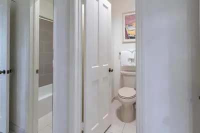 a white bathroom with a toilet and a shower at Wave Crest Resort in San Diego