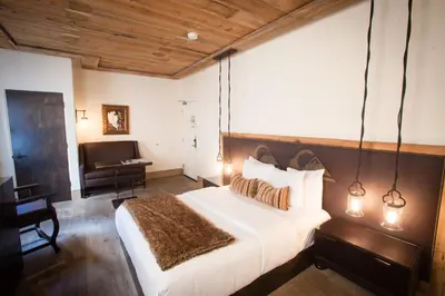 a bedroom with a large bed and a piano at La Casa Del Camino in Laguna Beach