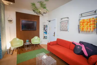 a living room with a red couch and a table at La Casa Del Camino in Laguna Beach