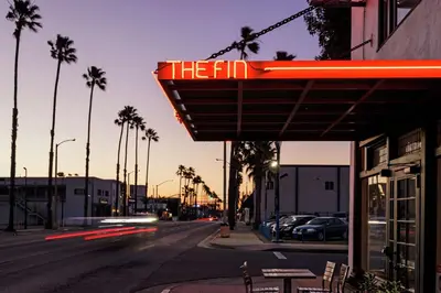 a sign that reads the inn on a city street at The Fin Hotel, Tapestry Collection by Hilton in Oceanside