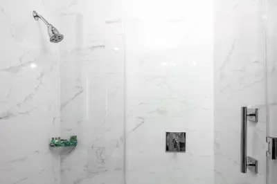 a bathroom with a shower with white marble walls at The Fin Hotel, Tapestry Collection by Hilton in Oceanside