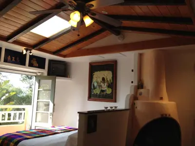 a bedroom with a ceiling fan and a bed and a window at Les Artistes Inn in San Diego