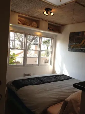 a bedroom with a bed and two windows at Les Artistes Inn in San Diego