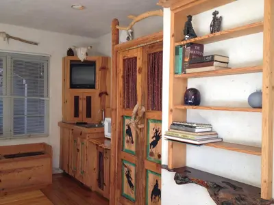 a room with wooden shelves and a tv in a room at Les Artistes Inn in San Diego
