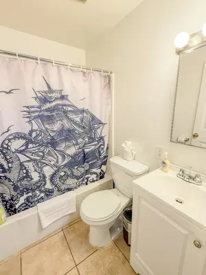 a bathroom with a white toilet and a shower curtain at 3bd Little Italy Cottage A++ Location in San Diego