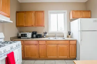 a kitchen with wooden cabinets and a white refrigerator at 3bd Little Italy Cottage A++ Location in San Diego