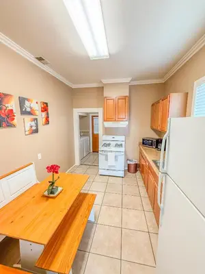 a kitchen with a wooden table and a refrigerator at 3bd Little Italy Cottage A++ Location in San Diego