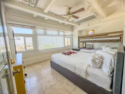 a bedroom with two beds and a ceiling fan at Mayor's Manor; Historic Downtown Mansion in San Diego