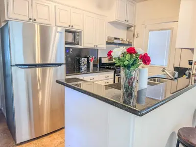 a stainless steel refrigerator in a kitchen with a vase of flowers at Mayor's Manor; Historic Downtown Mansion in San Diego