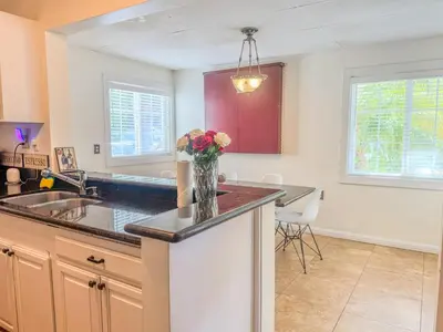 a kitchen with a vase of flowers on a counter at Mayor's Manor; Historic Downtown Mansion in San Diego