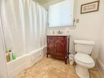 a bathroom with a toilet and a tub and a sink at Mayor's Manor; Historic Downtown Mansion in San Diego
