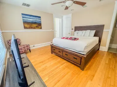 a bedroom with a bed and a flat screen tv at Mayor's Manor; Historic Downtown Mansion in San Diego