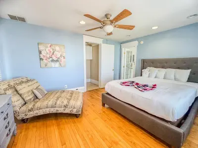 a bedroom with a bed and a couch and a ceiling fan at Mayor's Manor; Historic Downtown Mansion in San Diego
