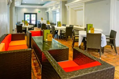 a dining room with tables and chairs and a piano at Balboa Inn, On The Beach At Newport in Newport Beach