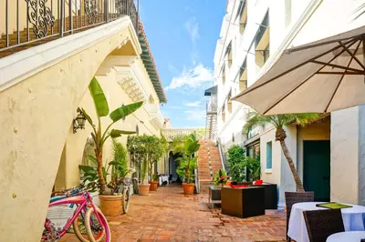 an alley with a pink bike parked next to a building at Balboa Inn, On The Beach At Newport in Newport Beach