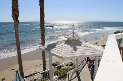 a view of the beach from the balcony of a beach house at Capri Laguna on the Beach - A Boutique Hotel in Laguna Beach