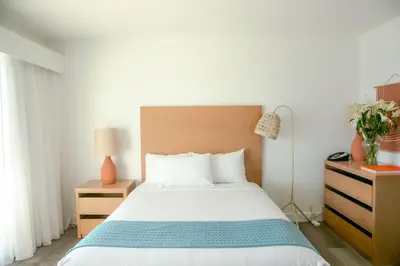 a bedroom with a large bed with a wooden headboard at Capri Laguna on the Beach - A Boutique Hotel in Laguna Beach
