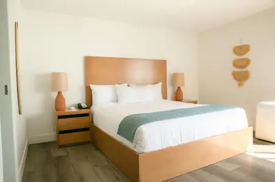 a bedroom with a large bed with a wooden headboard at Capri Laguna on the Beach - A Boutique Hotel in Laguna Beach