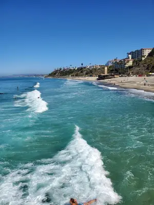 a person laying on the beach in the water at Casa Tropicana in San Clemente