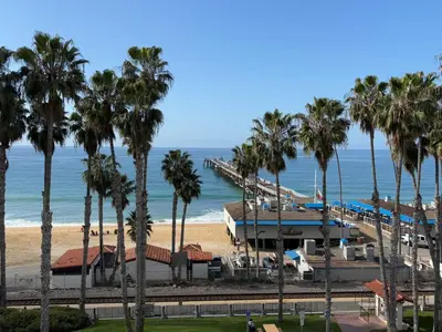 a view of the beach and a resort with palm trees at Casa Tropicana in San Clemente