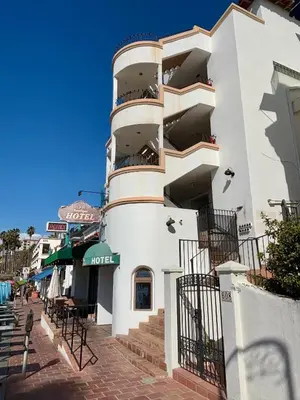 a white building with balconies on a street at Casa Tropicana in San Clemente