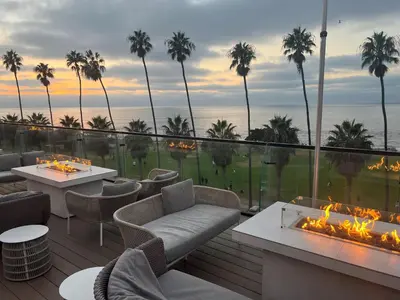 a patio with tables and chairs and a fire pit at La Jolla Cove Suites in San Diego