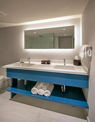 a bathroom with a sink with a mirror and towels at La Jolla Cove Suites in San Diego