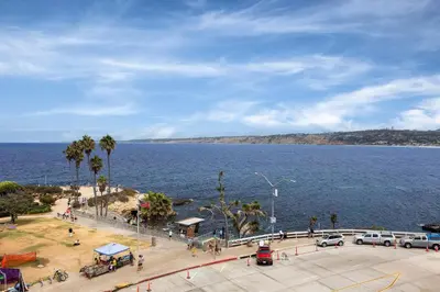 a view of a large body of water with cars parked at La Jolla Cove Suites in San Diego