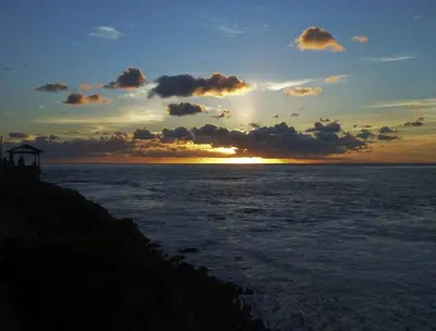 a sunset over the ocean with the sun setting at Pantai Inn in San Diego