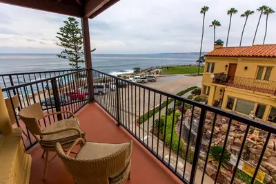 a balcony with chairs and a view of the ocean at Pantai Inn in San Diego