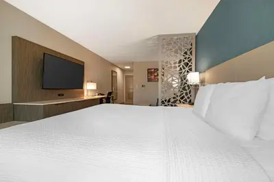 a large bedroom with a white bed and a flat screen tv at Best Western Plus Temecula Wine Country Hotel & Suites in Temecula
