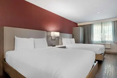 two beds in a hotel room with red walls at Best Western Plus Temecula Wine Country Hotel & Suites in Temecula