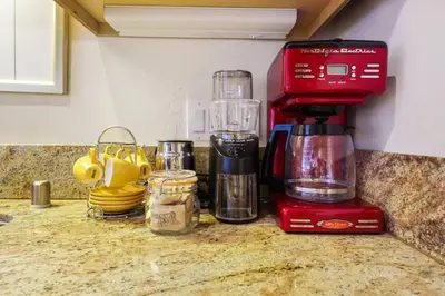 a red blender sitting on top of a counter at Ocean Beach Pier Condo in San Diego
