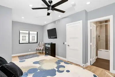 a living room with a ceiling fan and a tv at 308 35th Street, Unit A (Lower) in Newport Beach