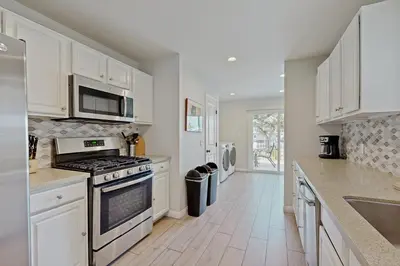 a kitchen with white cabinets and a stove top oven at Villa Del Mar in San Clemente