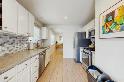 a kitchen with white cabinets and stainless steel appliances at Villa Del Mar in San Clemente