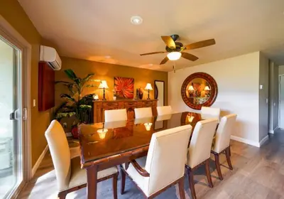 a dining room table with white chairs and a ceiling fan at San Vicente Golf Resort in Ramona