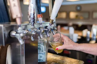 a person is pouring a glass of wine at San Vicente Golf Resort in Ramona