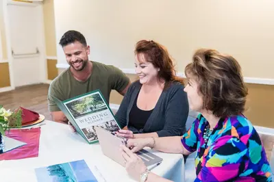 a group of people sitting around a table with a laptop at San Vicente Golf Resort in Ramona