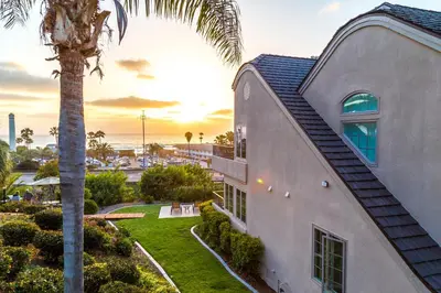 a house with a palm tree next to a building at Villa L'Auberge in San Diego