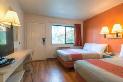 a hotel room with two beds and a flat screen tv at Motel 6-San Ysidro, CA - San Diego - Border in San Ysidro, San Diego